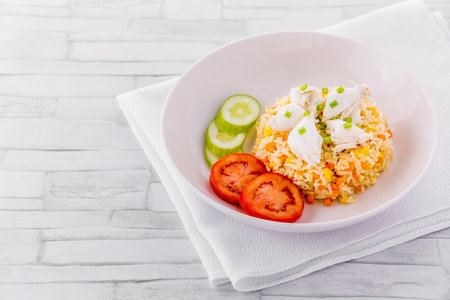 Crab meat fried rice on bright wooden backgroundの写真素材