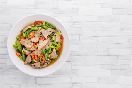 Stir fried onion flower stem with pork liver on bright wooden backgroundの写真素材