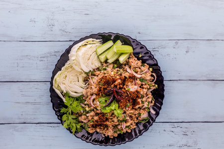 Spicy minced pork salad on blue wooden backgroundの写真素材