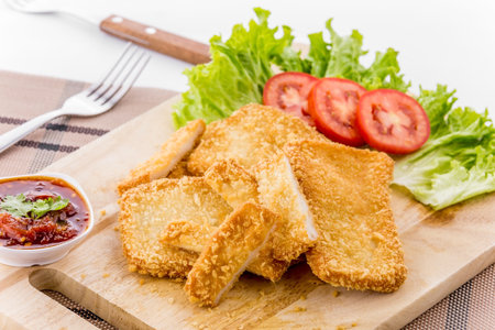Breaded fish chips on wooden plate backgroundの写真素材