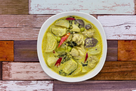 Thai food chicken green curry on old wooden background top viewの写真素材