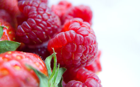 juicy strawberries and raspberry, close-up view, background