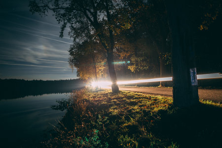 night drive through the woods with a car, a light footprint capturedの写真素材
