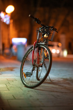 the old bicycle on a stand in the square at nightの写真素材