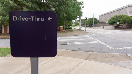 A drive-thru sign on the corner of the streetの写真素材