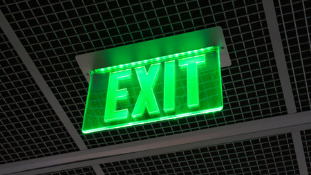 A green exit sign on the ceilingの写真素材