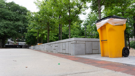 A yellow recycling bin on the streetの写真素材