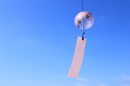 Japanese wind chime against blue skyの写真素材