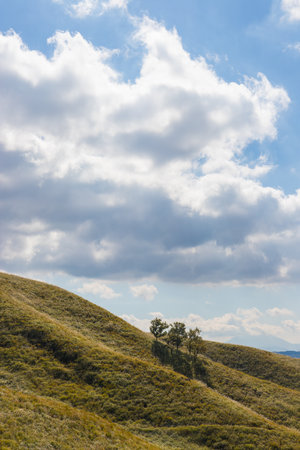 Beautiful spring landscape with blue sky and white clouds over hills.の写真素材