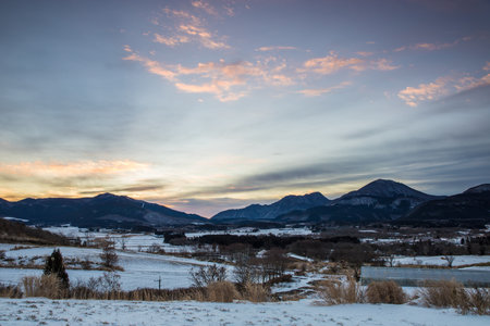 Beautiful winter landscape and dawn with snow-capped mountains in the backgroundの写真素材