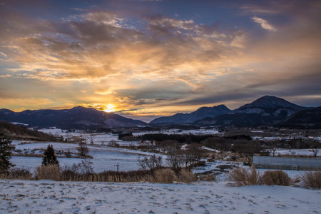 Beautiful winter landscape and dawn with snow-capped mountains in the backgroundの写真素材