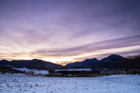 Beautiful winter landscape and dawn with snow-capped mountains in the backgroundの写真素材