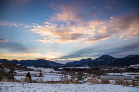 Beautiful winter landscape and dawn with snow-capped mountains in the backgroundの写真素材