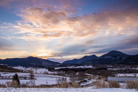 Beautiful winter landscape and dawn with snow-capped mountains in the backgroundの写真素材