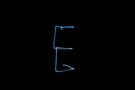 Long exposure small neon lights letter E texture. Abstract colourfull neon light.の写真素材