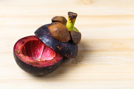 Mangosteen and cross section showing the thick purple skinの写真素材