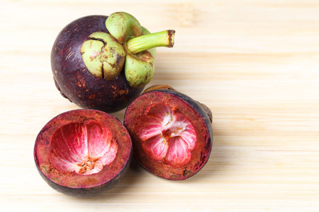 Mangosteen and cross section showing the thick purple skinの写真素材