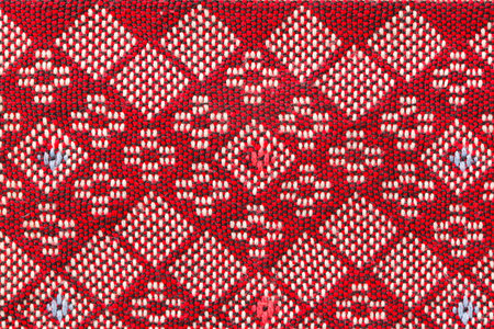 Red thai silk fabric pattern background. Old handmade.