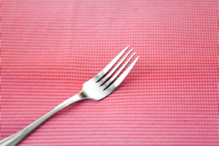 Abstract blur Silver fork and spoon on red fabrick. Selective focus.の写真素材