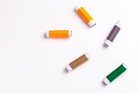 Multicolor sewing threads on white background.の写真素材