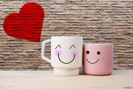 Two happy cups on the wood table with glass surface windows. love concept in rain season.の写真素材