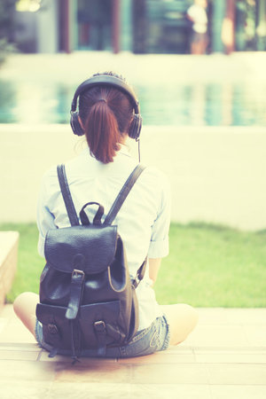 Girl listening music with headphone sitting alone, Asian girl style.の写真素材