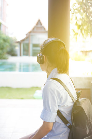 Girl listening music with headphone sitting alone, Asian girl style.の写真素材
