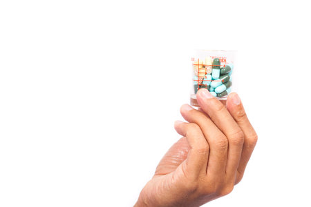 Doctor or medic holding and showing pill isolated on white background.の写真素材