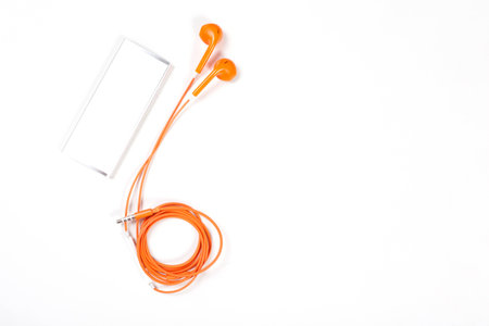 orange color earphone with music player on white background.の写真素材