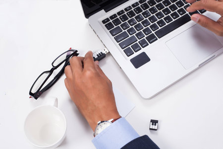 Business man plug in USB on notebook in office.の写真素材