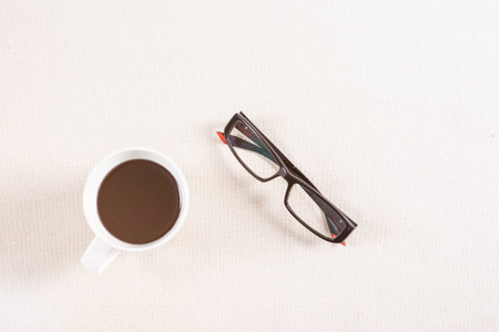 black coffee and eyeglass on fabric background.の写真素材