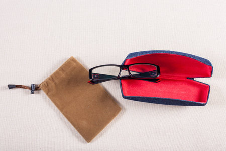 eyeglass and red boxed on fabric background.の写真素材