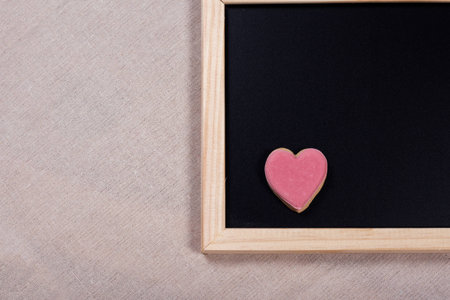 Valentine background and pink cookie on slate blackboard. Ideas for valentine's love concept.