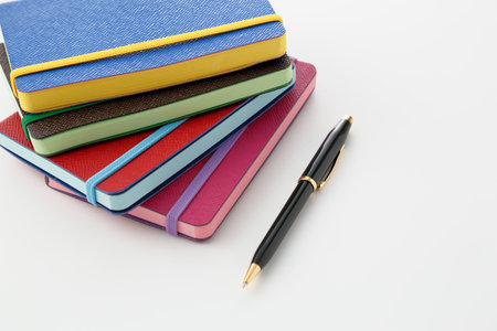 Colorful notebooks and ballpoint pensの写真素材
