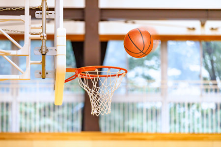 Basketball Rings and Balls in a Beautiful Gymnasiumの写真素材