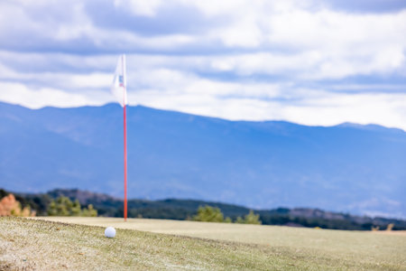 Cloudy golf course and white golf ballの写真素材