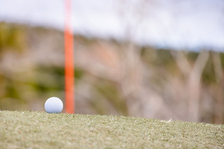 Cloudy golf course and white golf ballの写真素材