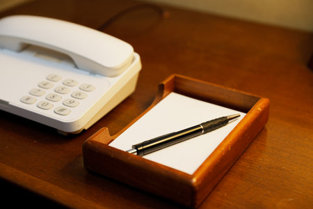 Telephone and writing utensils provided in the room at the resort hotelの写真素材