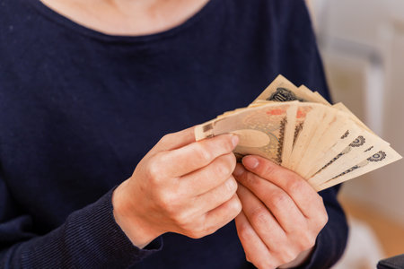 a woman counting money for household financesの写真素材