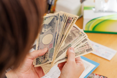 a woman counting money for household finances