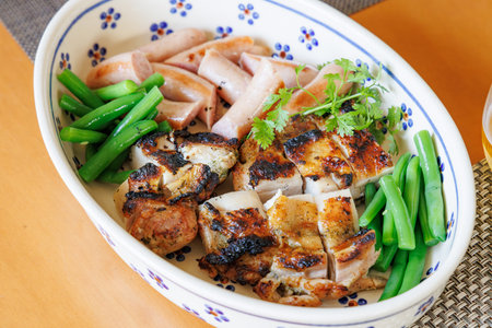 Grilled chicken with green beans in a bowl.の写真素材