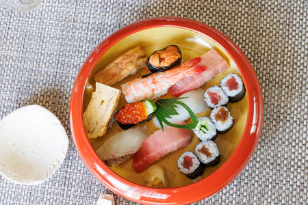 Sushi set in a ceramic bowl on a table in a restaurantの写真素材