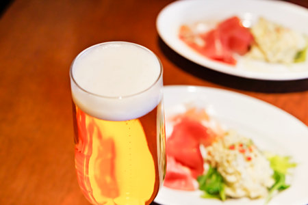 Glass of beer with japanese food on wooden table in restaurant