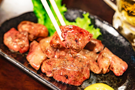 Grilled meat with chopsticks on a plate in a restaurant.の写真素材
