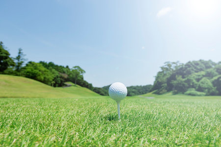 Beautiful green golf course and white ballの写真素材