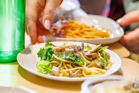 Pasta with plenty of arugula and mushrooms in an oil sauceの写真素材