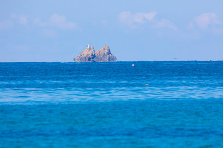 Rocky island in the middle of the sea on a sunny dayの写真素材