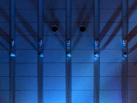 Background image of a textured wall of made concrete, lightly lit by a blue spotlightの写真素材