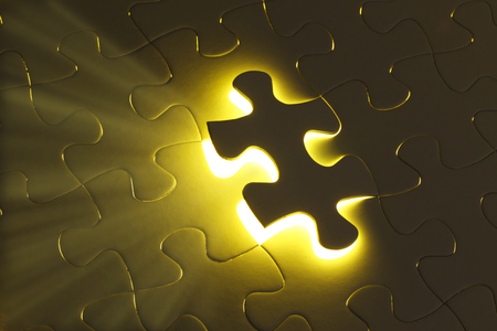 Missing jigsaw puzzle piece with light glowの写真素材