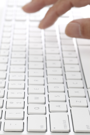 Typing on a White Computer Keyboardの写真素材